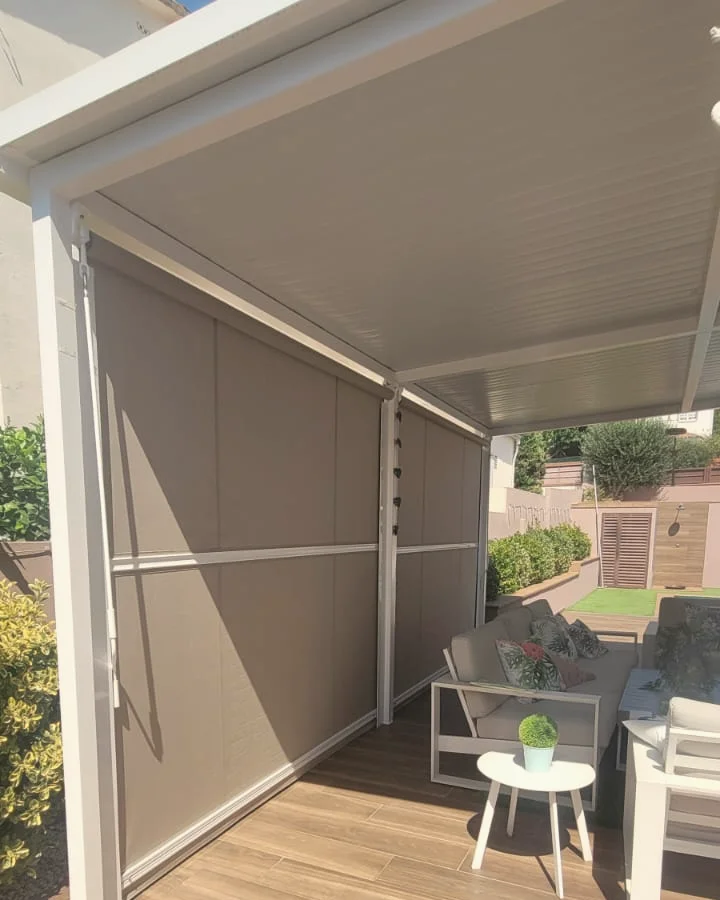 Pérgola con toldos verticales en tono taupe sobre una terraza con sofás de exterior, instalada por Línea Hogar
